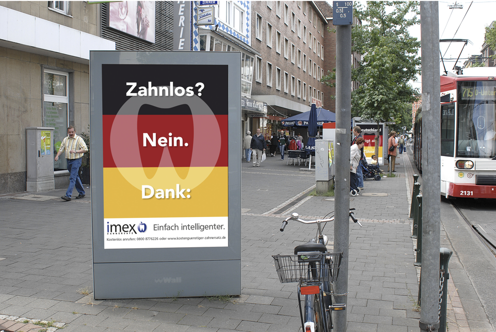 Foto einer STraßembahnhaltestelle mit imex City-Light Poster mit dem Motiv 'Zahnlos? Nein. Dank: imex Zahnersatz.'